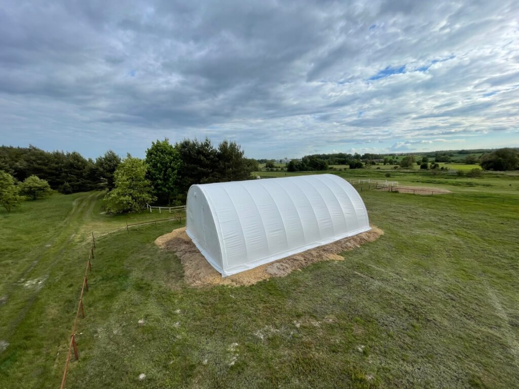 Rundbogenhalle aus der Luft – große Lagerfläche auf Grünland/landwirtschaftlichem Gelände
