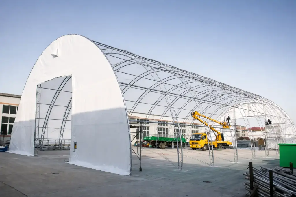 Rundbogenhalle weiß – überdachter Arbeitsbereich mit Fahrzeug/Maschine