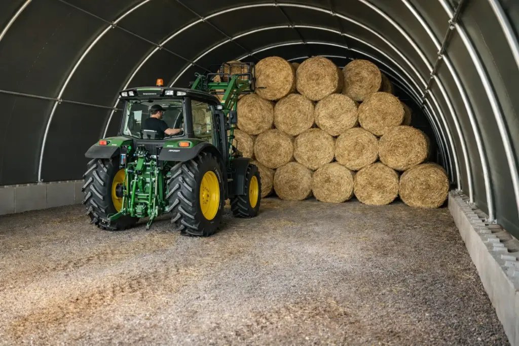Rundbogenhalle als Strohlager – Ballenlagerung mit Traktor im Innenraum