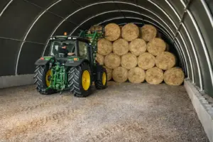 Rundbogenhalle als Strohlager – Ballenlagerung mit Traktor im Innenraum